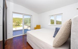 a white bedroom with a large bed and windows at Stunning Home In Trogir in Prapatnica