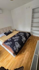 a bed in a room with a wooden floor at Bazen za uzivanje in Petrovaradin