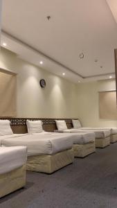 a row of beds in a large room at فندق شركة وردة الوادي توصيل من والي الحرم 24 مجاني in An Naqāʼ
