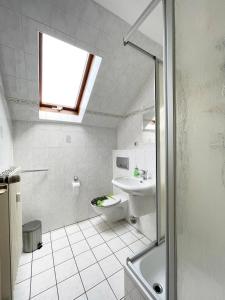a white bathroom with a sink and a toilet at Ferienwohnung Seeglück - 4 Schlaf- & 4 Badezimmer in Tauche +19 photos