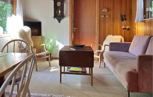 a living room with a couch and a table at Amazing Home In Aakirkeby With Wifi in Boderne