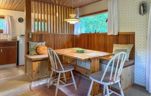 a kitchen with a wooden table and two chairs at Amazing Home In Aakirkeby With Wifi in Boderne