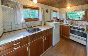 a kitchen with a sink and a stove at Amazing Home In Aakirkeby With Wifi in Boderne