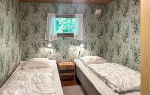 a bedroom with two beds and a window at Amazing Home In Aakirkeby With Wifi in Boderne +7 photos