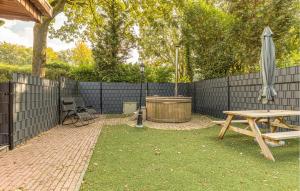 una mesa de picnic y una sombrilla junto a una valla en Cozy Home In Erm With Private Swimming Pool, Can Be Inside Or Outside, en Erm