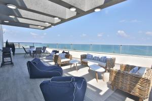 una terrazza con divani e sedie su una nave da crociera di Luxe on the BEACH By LIME a Haifa