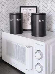 a microwave with two cups on top of it at nestup - Zentrales Apartment mit Boxspringbetten, Smart-TV und ausgestatteter Küche in Kassel +33 photos