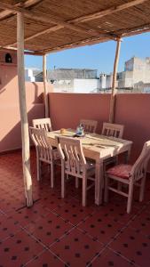 a wooden table and chairs on a roof at La casa de Oasis in Essaouira