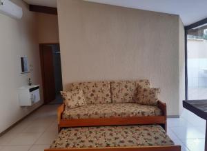 un sofá sentado en la esquina de una habitación en Pousada Ilha Sul, en Cananéia