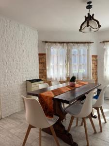 a dining room with a wooden table and white chairs at Chalet Mar del Plata in Mar del Plata