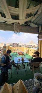 two men sitting around a table in a room with a view at Eyad Pyramids view in Cairo