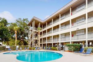 a hotel with a swimming pool in front of a building at Oceanfront Condo - Hilton Head Island in Hilton Head Island