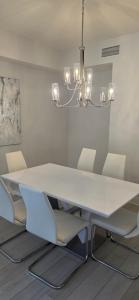 Un comedor con una mesa y sillas blancas. en Modern & Luxurious 3BR Retreat!, en Orlando