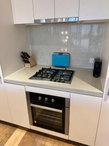 a kitchen with a stove with a blue box on it at Fortitude Valley Stylish Comfortable Apartment in Brisbane +15 photos
