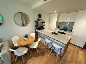 a kitchen with a counter and a table and chairs at Fortitude Valley Stylish Comfortable Apartment in Brisbane