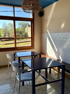 two tables and chairs in a room with a window at Azul Hotel & Spa in Oberá