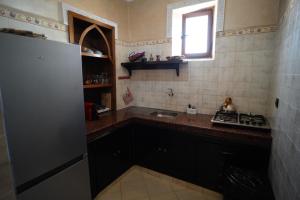 a small kitchen with a sink and a refrigerator at Entre Medina et Mer Duplex in Rabat