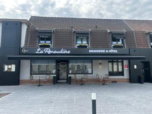 a building with tables and chairs in front of it at La Renaudière in Isbergues