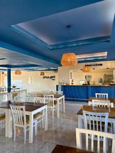 a restaurant with white tables and chairs and a blue ceiling at Azul Hotel Oberá in Oberá