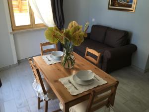 a dining room table with a vase of flowers on it at Camere La Forgia in Lazise