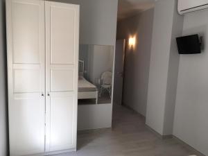 een witte kast in een kamer met een slaapkamer bij Camere La Forgia in Lazise