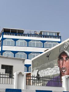 a building with a large painting of a man on it at Ami D'or Hostel in Taghazout