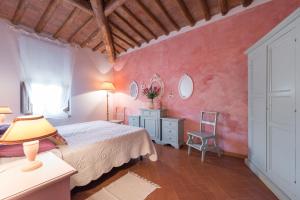 Podere Torricella في Montagnana Val di Pesa: غرفة نوم بسرير وجدار وردي