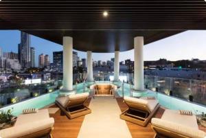 a balcony with chairs and a view of a city at Fortitude Valley Stylish Comfortable Apartment in Brisbane