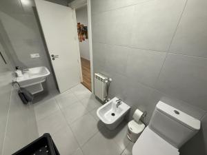 a white bathroom with a toilet and a sink at Vut ILLA PANCHA in Ribadeo