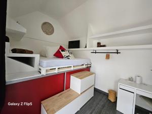 BazancourtにあるLa Nichée, maison Cosyのベッドと机のある小さな部屋