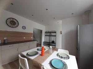 BazancourtにあるLa Nichée, maison Cosyの白いテーブルと青い皿のあるキッチン