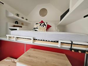 BazancourtにあるLa Nichée, maison Cosyの赤い壁のドミトリールームのベッド1台分です。