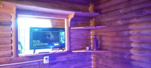 a television sitting in a window in a log cabin at Los Espinillos Cabaña Exclusiva in Huerta Grande