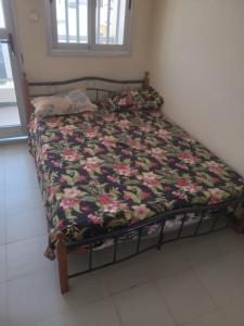 un lit avec une couette fleurie dessus dans une chambre dans l'établissement Hébergement 4 pièces Dakar, à Darou Rhamane