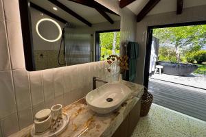 コールドストリームにあるThe Pavilion Yarra Valley luxury country retreatの洗面台、鏡、浴槽のあるバスルーム