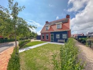 una casa roja y azul con patio en Sea Quality 83, en Colijnsplaat