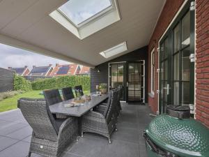 Un patio con una mesa y sillas y una ventana. en Sea Quality 83, en Colijnsplaat