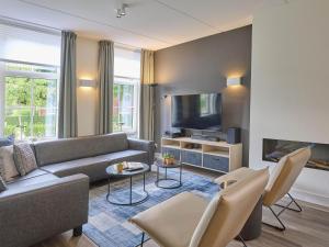 Una sala de estar con un sofá y un televisor. en Sea Quality 83, en Colijnsplaat