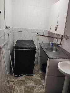 Una pequeña cocina con un fregadero y una lavadora negra. en Espaço Ideal Apartamento 2 Quartos, en Cascavel 8 fotos más