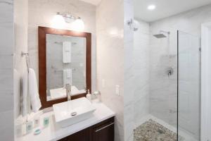 une salle de bain blanche avec un lavabo et une douche dans l'établissement Esencia Premiere, à Providenciales
