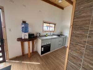 a small kitchen with a sink and a stove at Cabaña Buchupureo in Buchupureo