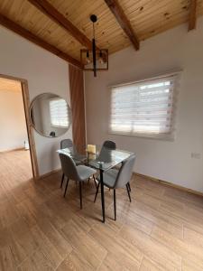 a dining room with a glass table and chairs at Cabaña Buchupureo in Buchupureo