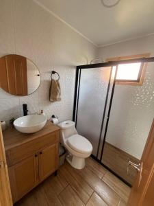 a bathroom with a toilet and a sink and a shower at Cabaña Buchupureo in Buchupureo