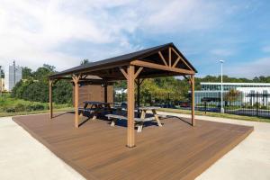 a wooden gazebo with a picnic table and a bench at Extended Stay America Suites - Columbia - Greystone in Columbia