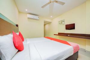 ハイデラバードにあるHotel O Kachiguda Railway Stationのベッドルーム(赤い枕のベッド1台、テレビ付)