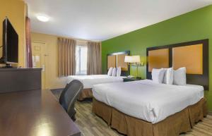 a hotel room with two beds and a flat screen tv at Extended Stay America Suites - Albuquerque - Airport in Albuquerque