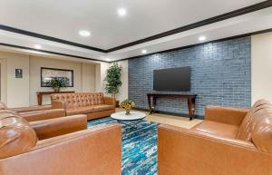 ein Wohnzimmer mit Ledermöbeln und einem Flachbild-TV in der Unterkunft Extended Stay America Suites - McAlester - Hwy 69 in McAlester