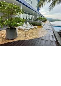 a row of white chairs on a boardwalk next to a building at Semarak Homestay@Alisya Package in Kajang