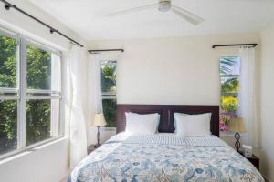 a bedroom with a bed and two windows at Wyakha Duplex 1 & 2 in Long Bay Hills