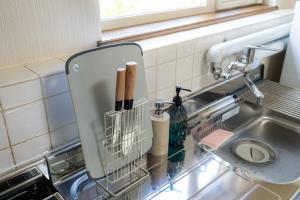 een gootsteen met een droogrek ernaast bij ウィステリア in Teshikaga +43 foto's